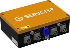 SUNCAR power module: orange lid on a black chassis with multiple DC connectors (INLET DC+, INLET DC-, VEHICLE DC+, VEHICLE DC−), a blue switch/knob, and a yellow warning sticker on the front edge.